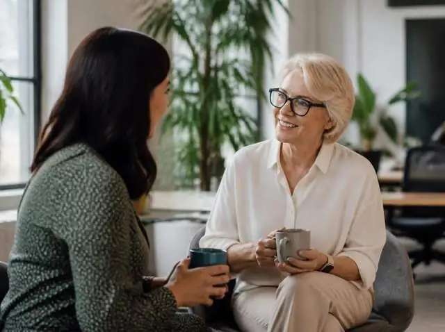 Two colleagues talking over coffee in a bright, modern office